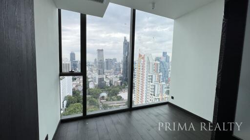 Bright spacious room with floor-to-ceiling windows offering a panoramic city view