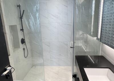 Modern bathroom with glass shower enclosure and white marble walls