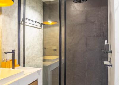 Modern bathroom interior with glass shower cabin and marble accents