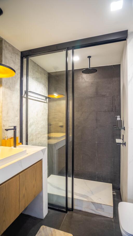Modern bathroom interior with glass shower cabin and marble accents