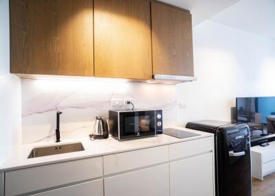 Modern kitchen with wooden overhead cabinets and marble backsplash