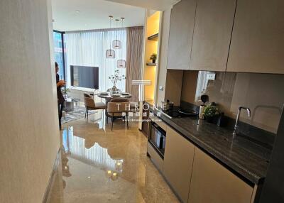 Modern kitchen with marble floors and integrated appliances leading to a dining area