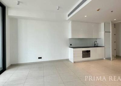 Spacious unfurnished apartment interior with open floor plan, kitchen, and large windows