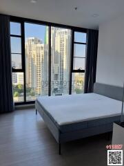 Contemporary bedroom with large windows overlooking the city