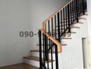 Modern staircase with wooden steps and black metal railing in a house