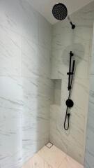 Modern bathroom with marble tiles and rainfall showerhead