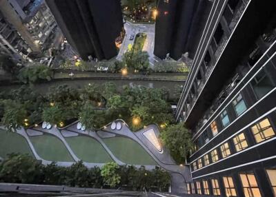 Aerial view of residential building complex gardens and amenities, with surrounding cityscape at dusk