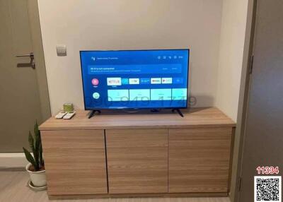 Modern living room with a large television and wooden cabinet