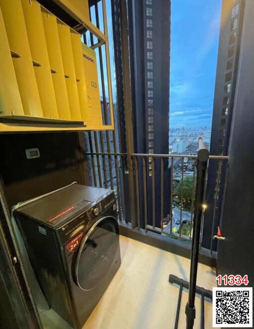 Compact laundry room with modern washing machine and city view