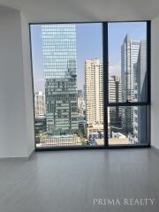 Modern bedroom with large window overlooking the city skyline