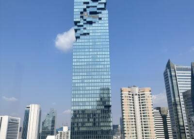 Modern high-rise building with glass facade against a clear blue sky