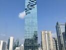 Modern high-rise building with glass facade against a clear blue sky