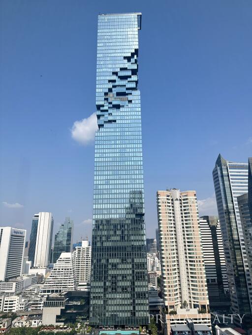 Modern high-rise building with glass facade against a clear blue sky