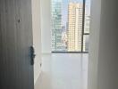 View into an apartment interior showcasing the cityscape through large windows