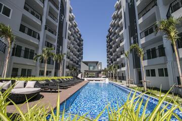 Modern residential complex with swimming pool and lounge chairs