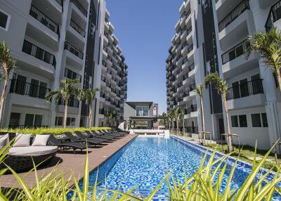 Modern residential complex with swimming pool and lounge chairs
