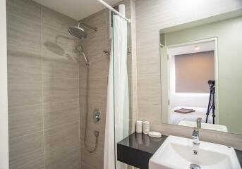 Modern bathroom with walk-in shower, neutral tile, and clean design