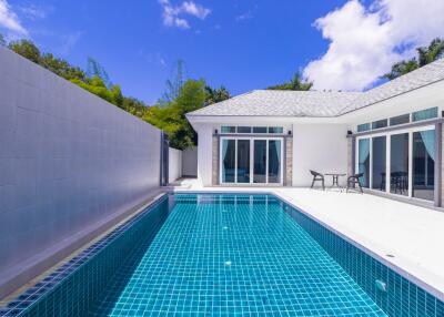 Bright and modern outdoor pool area with adjacent house and clear blue sky