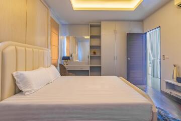 Modern bedroom interior with a comfortable bed, built-in wardrobe, and natural light