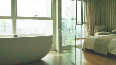 Luxurious bedroom with en-suite open bathroom and cityscape view