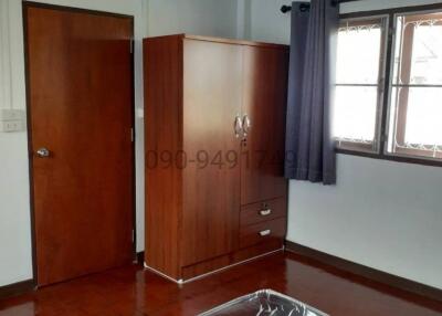 Spacious bedroom with wooden wardrobe and polished flooring