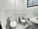 Compact white tiled bathroom with modern fixtures