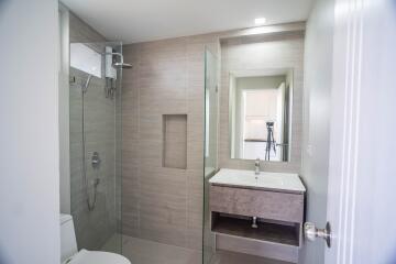 Modern bathroom with walk-in shower, vanity, and large mirror