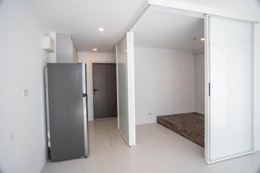 Bright bedroom interior with sliding door closet and refrigerator