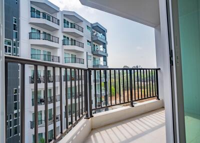 Spacious balcony with a view of apartment building exteriors and clear skies