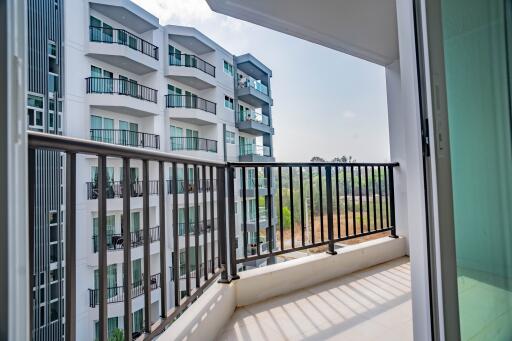 Spacious balcony with a view of apartment building exteriors and clear skies