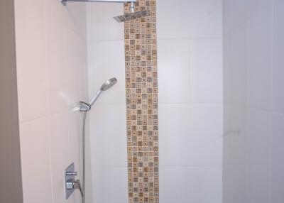 Modern bathroom with a wall-mounted shower and decorative tiles