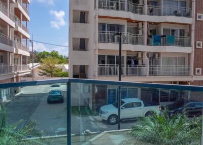 Spacious balcony with glass balustrade overlooking the street and adjacent buildings