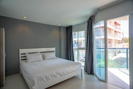 Spacious bedroom with a large bed and balcony access