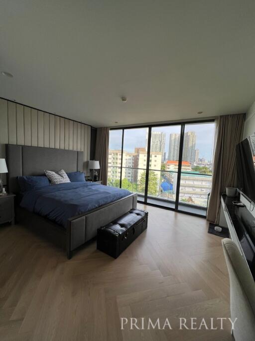 Spacious bedroom with large windows and city view