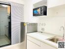 Compact modern kitchen with stainless steel appliances and white cabinets