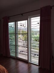 Cozy bedroom with large glass doors leading to the balcony with a scenic view