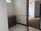 Brightly lit house corridor with white tiled flooring and wooden doors