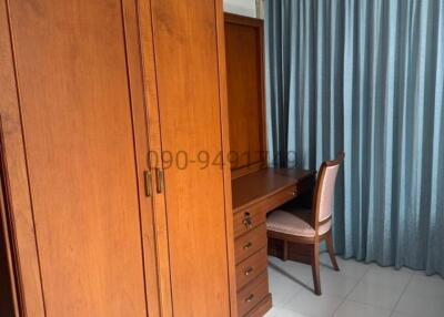 Spacious bedroom with wooden wardrobe and study desk