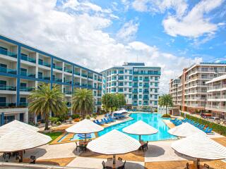 Modern residential complex with central swimming pool and lounge chairs