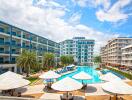 Modern residential complex with central swimming pool and lounge chairs