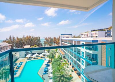 Balcony view of a luxurious residential complex with a swimming pool and sea view
