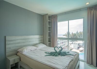 Bright bedroom with large window and ocean view