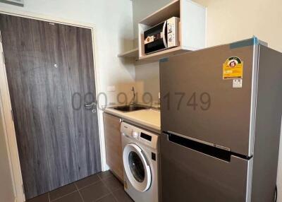 Compact kitchen with modern appliances and grey tiling