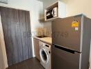 Compact kitchen with modern appliances and grey tiling