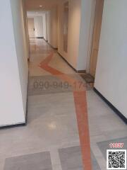 Spacious hallway inside a building with tiled floors and directional arrows