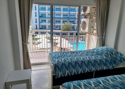 Bedroom with ocean-themed bedding and balcony view