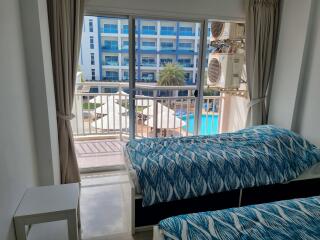 Bedroom with ocean-themed bedding and balcony view