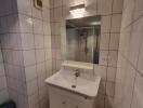 Contemporary white tiled bathroom with sink and mirror