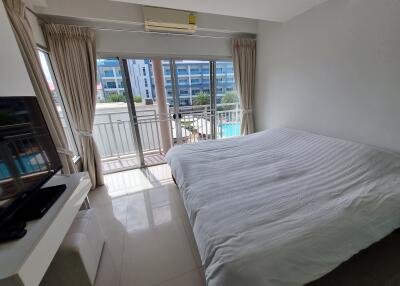 Bright bedroom with double bed, balcony access, and air conditioning