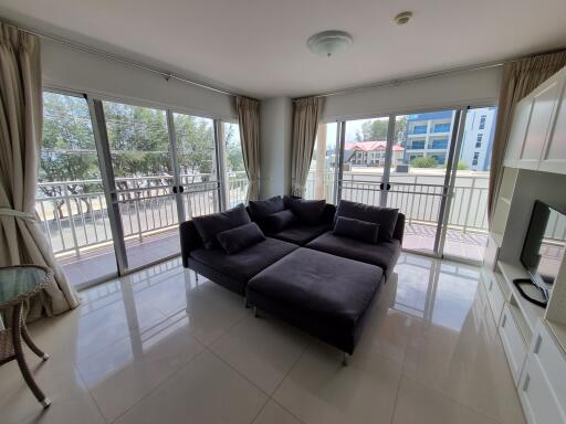 Spacious living room with large sectional sofa and balcony access